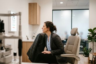 Femme en tenue de bureau passant un contrôle de vue dans une clinique optométrique moderne installée près du lieu de travail