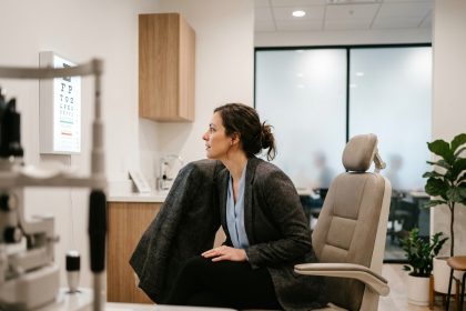 Femme en tenue de bureau passant un contrôle de vue dans une clinique optométrique moderne installée près du lieu de travail