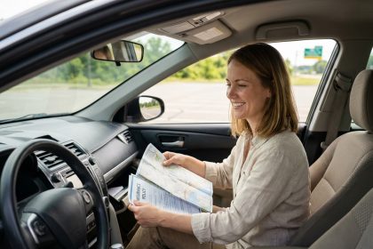 Femme préparant ses documents d'assurance auto avant un départ en vacances dans sa voiture