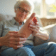 Senior examinant ses pieds propres sur un sofa lumineux